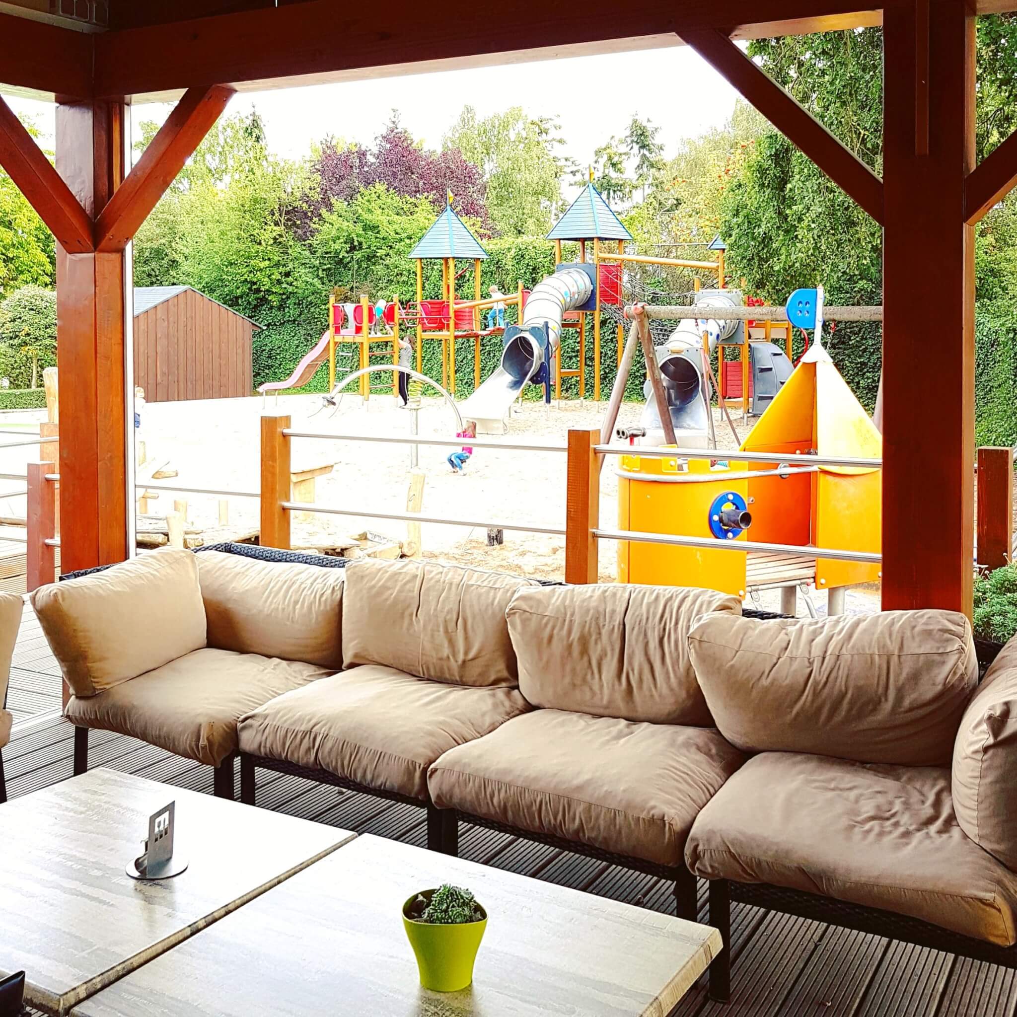 Landal Mont Royal: spelen, zwemmen en wijnproeven met een panoramisch uitzicht - terras restaurant Woods naast speeltuin