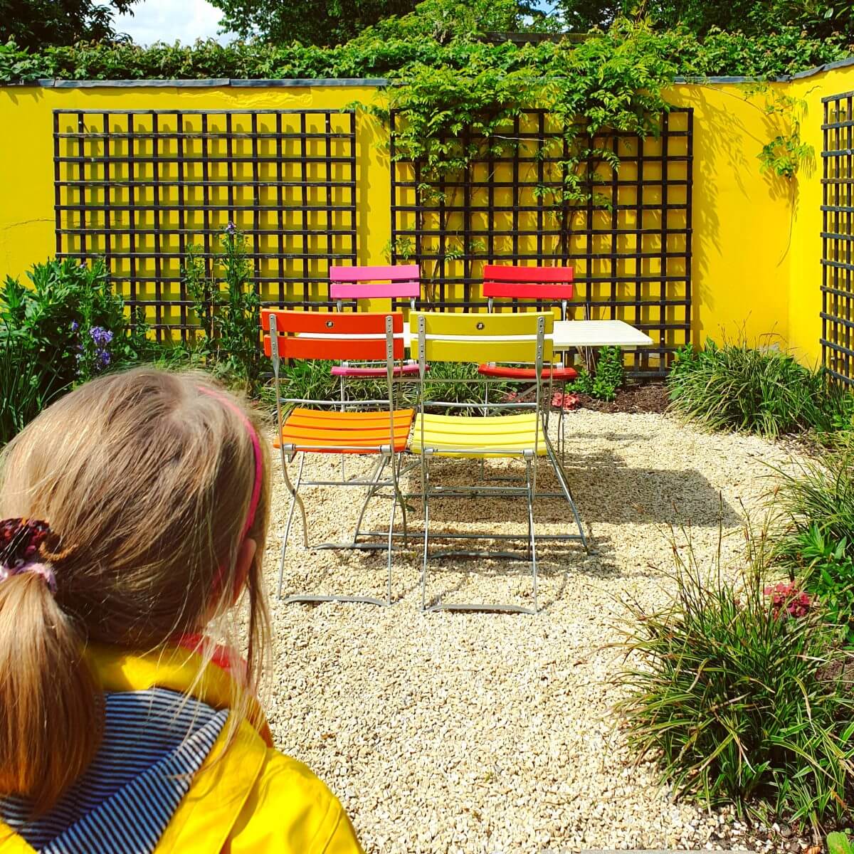 kleur in een kindvriendelijke tuin met een geverfde muur, schutting, tuinhuisje of schuur