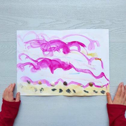 Kleine meis maakte op school dit schilderij van schelpen. Eerst schilderde ze de lucht en het strand, daarna plakte ze met knutsellijm de schelpen er op.