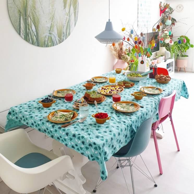 Paasdecoratie: ideeën om het huis voor Pasen te versieren. De tafel wordt feestelijk met paastakken, kleurrijk servies, servetten en een tafelkleed.
