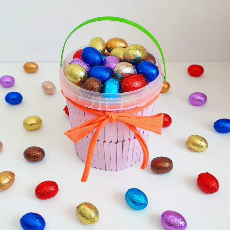 Paasmandje voor paaseieren knutselen, met de kinderen voor Pasen. Van een groentebakje, ijsstokjes en zpaghetti touw- easter bucket crafting