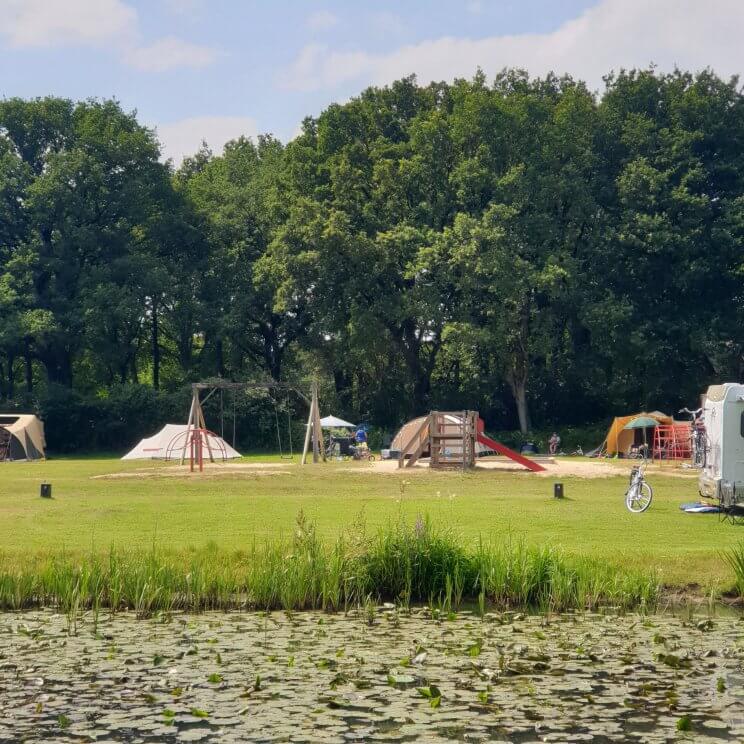 Huttopia de Roos: review van kindvriendelijke natuur camping in Overijssel. Er zijn veel verschillende speeltuinen, dit is de speeltuin bij plek 107. Er is onder meer een schommel, klimrek en glijbaantje. Kleine meis en haar vriendinnen gingen er heen als wij op het terras aan de andere kant van het water zaten. 