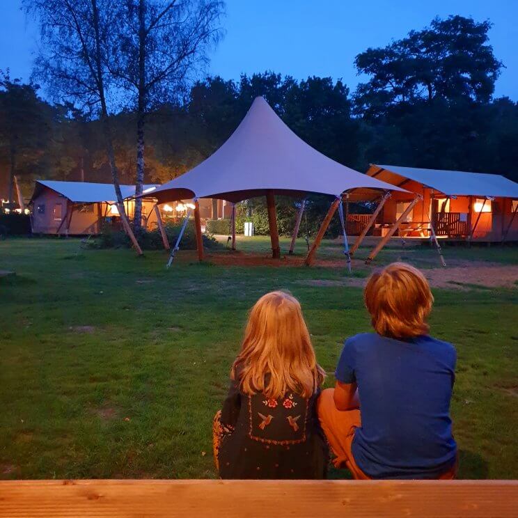 De safaritenten glamping Landal Gooise Heide liggen midden in het bos. Wij verbleven in de 4-6-persoons safaritent. Deze tent heeft twee slaapkamers, een met een 2-persoonsbed en een met twee stapelbedden. De woonkamer heeft een grote tafel, zithoek, keuken en veel ruimte. Daarnaast heb je een eigen badkamer. Buiten op de veranda zijn zowel een picknicktafel als een loungehoek. Fijn voor hondenliefhebbers: je mag je hond meenemen. Sommige safaritenten zijn ook speciaal voor honden uitgerust, bijvoorbeeld met een bench en bakken. 