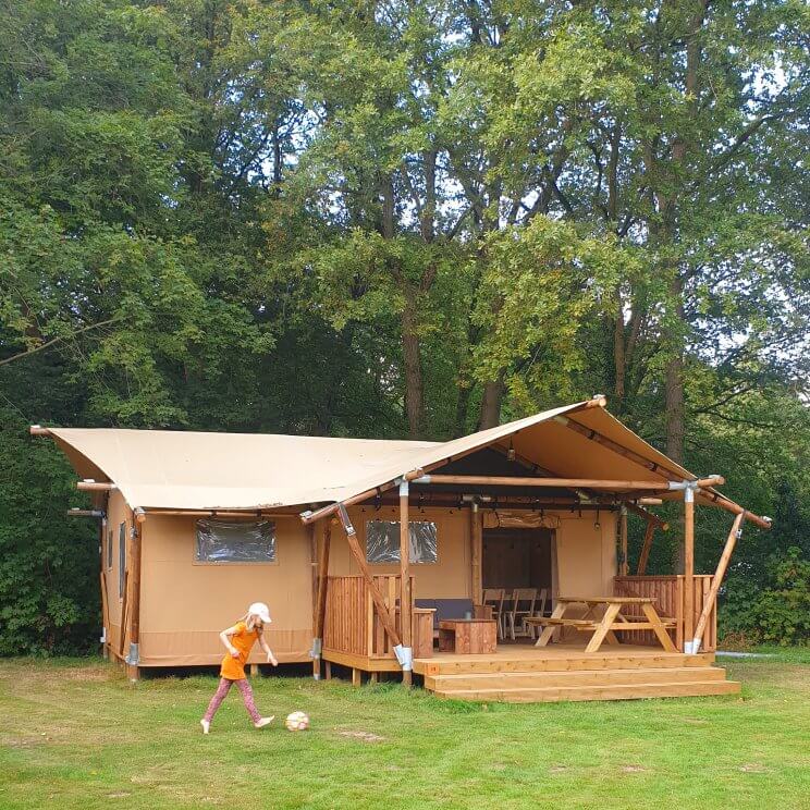 De safaritenten glamping Landal Gooise Heide liggen midden in het bos. Wij verbleven in de 4-6-persoons safaritent. Deze tent heeft twee slaapkamers, een met een 2-persoonsbed en een met twee stapelbedden. De woonkamer heeft een grote tafel, zithoek, keuken en veel ruimte. Daarnaast heb je een eigen badkamer. Buiten op de veranda zijn zowel een picknicktafel als een loungehoek. Fijn voor hondenliefhebbers: je mag je hond meenemen. Sommige safaritenten zijn ook speciaal voor honden uitgerust, bijvoorbeeld met een bench en bakken. 