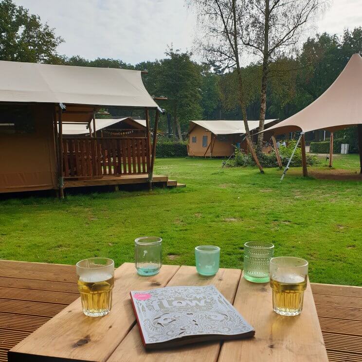 De safaritenten glamping Landal Gooise Heide liggen midden in het bos. Wij verbleven in de 4-6-persoons safaritent. Deze tent heeft twee slaapkamers, een met een 2-persoonsbed en een met twee stapelbedden. De woonkamer heeft een grote tafel, zithoek, keuken en veel ruimte. Daarnaast heb je een eigen badkamer. Buiten op de veranda zijn zowel een picknicktafel als een loungehoek. Fijn voor hondenliefhebbers: je mag je hond meenemen. Sommige safaritenten zijn ook speciaal voor honden uitgerust, bijvoorbeeld met een bench en bakken. 