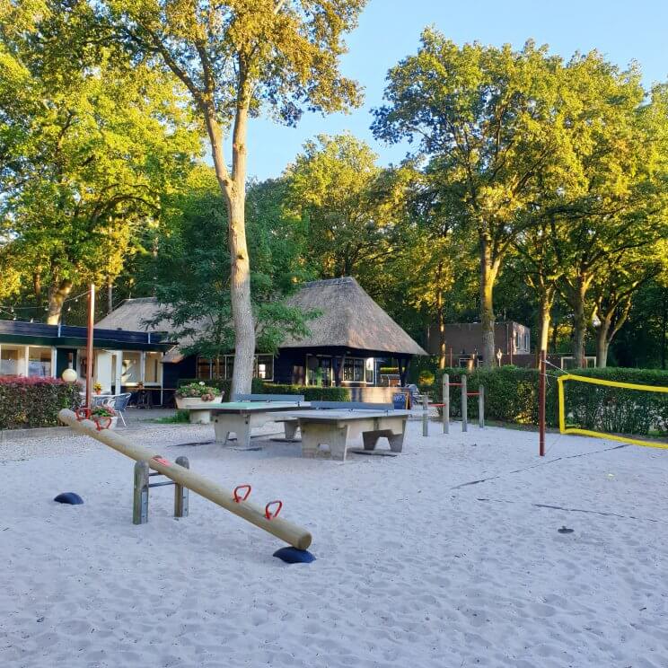 Glamping Landal Gooise Heide: safaritenten camping in het Gooi. Het park heeft een speeltuin, naast het terras van het restaurant. Er is een klimrek, duikelrek, wipwap, tafeltennistafel en beachvolleybalnet. Gelukkig lagen er ballen en tafeltennisbatjes, want die laatste waren we vergeten. Het is geen grote speeltuin, maar er zijn wel dingen voor verschillende leeftijden. Onze kids hebben zich er uren lang vermaakt met andere kids. 