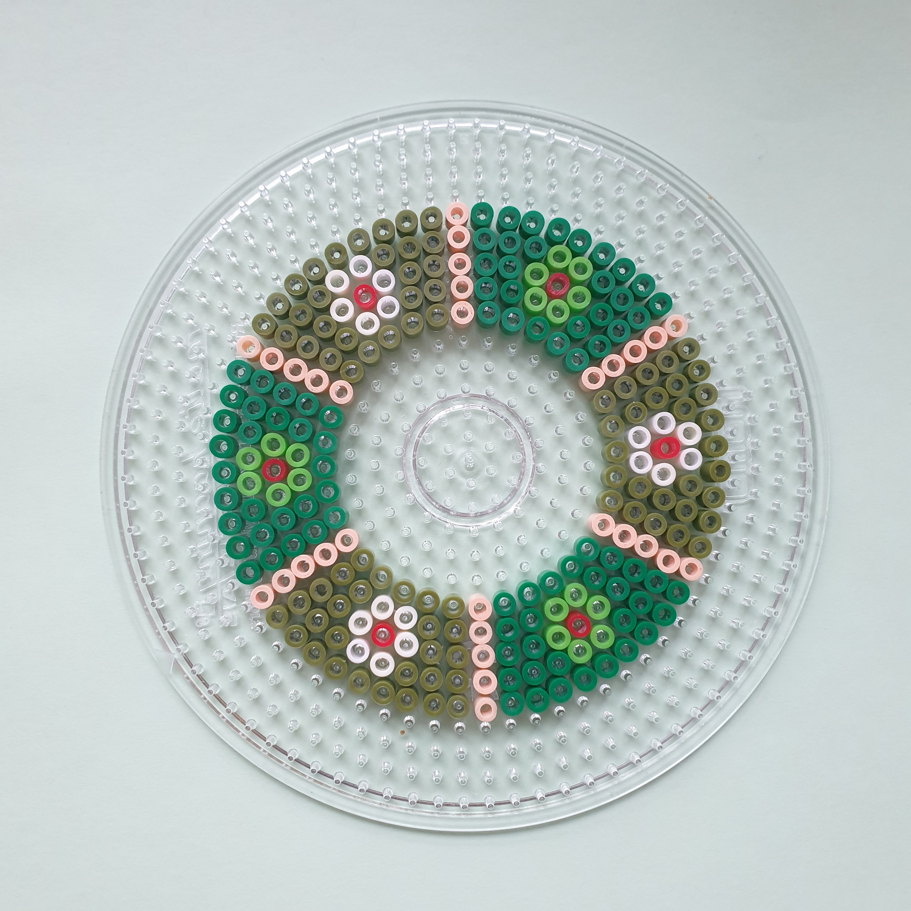 Kerst knutselen met strijkkralen: leuke ideeën. Deze kerstkrans is makkelijk te maken en extra leuk in je lievelingskleuren. 