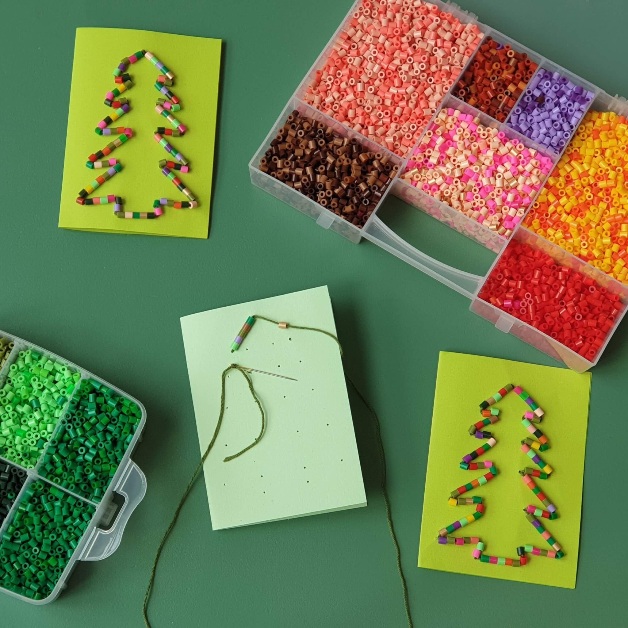 Kerstkaarten knutselen met kinderen: leuke ideeën. Voorbeelden voor kerstkaartje zelf maken met peuters en kleuters, maar ook voor grotere kinderen, tieners en volwassenen. Zoals deze kerstkaarten om te borduren met strijkkralen.