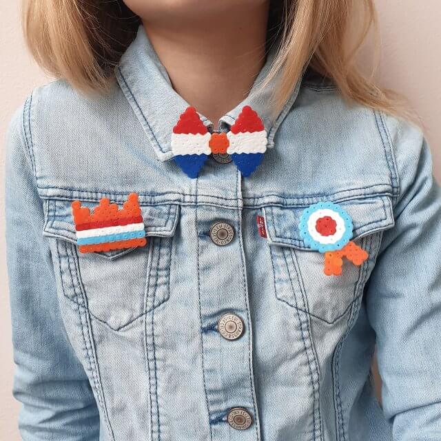 Knutselen voor Koningsdag en Oranje. De kids waren op zoek naar iets leuks om te verkopen op de vrijmarkt. Strijkkralen broches moesten het worden, besloten ze. We maakten ze heel eenvoudig. Een oranje kroon, een medaille, een strikje en een rood wit blauw hartje. 