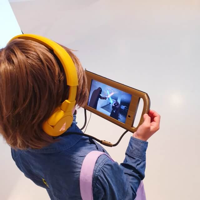 Het filmmuseum EYE heeft een aantal dingen ontwikkeld om speciaal met kinderen te doen. Zo is er de EYE walk videotour voor kinderen van 7 tot 12 jaar. Zoonlief en ik deden beide deze tour van ongeveer een half uur. Je krijgt een tablet met een koptelefoon, waarmee je langs de collectie wandelt. Historische personages lijken tegenover je te staan om hun verhaal te vertellen, waardoor ze tot leven komen. Ook de door hun ontwikkelde of gebruikte apparaten gaan daardoor leven.