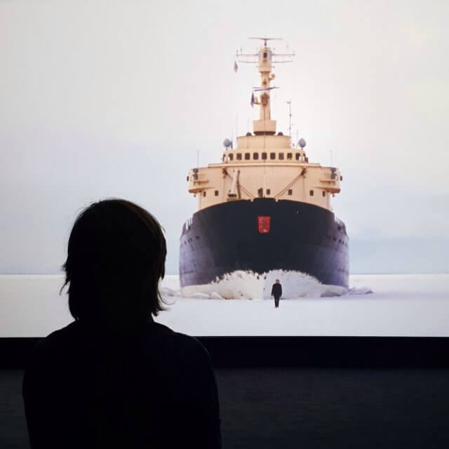 Filmmuseum EYE: leuk museum uitje met kinderen in Amsterdam Noord. Boven is een ruimte voor wisselende tentoonstellingen. Momenteel laat filmmuseum EYE werken van Guido van der Werve zien, met veel kinderen is dat ook leuk. De werken zijn absurdistisch, dat vond zoonlief interessant. Natuurlijk bleef hij niet zo lang kijken als sommige volwassenen, maar dat hoeft ook niet. 