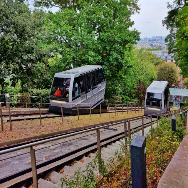 Montmartre met kinderen: tips in de sfeervolste wijk van Parijs. Je kunt met de funiculaire omhoog, dat is dat treintje dat tegen de berg opgaat. Net als de Montmartrobus is dit onderdeel van het openbaarvervoerbedrijf RATP. Een tip: koop bij het dichtstbijzijnde metrostation een metrokaartje, dan hoef je niet in de rij te staan. 