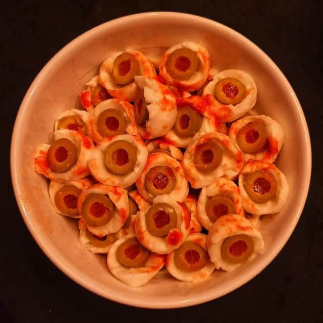 Halloween met kinderen: uitjes, recepten en je huis versieren. Zoals deze griezelige oogjes, gemaakt van mozarella bolletjes, olijven en ketchup. 