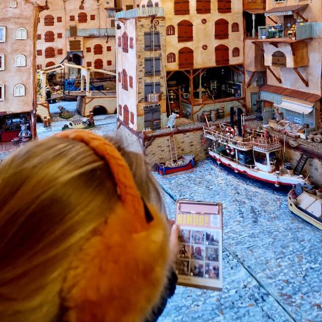 Je kunt het Muizenhuis in de Jordaan in Amsterdam bezoeken. In deze winkel annex minimuseum kijk je je ogen uit naar alle Muizenhuis tafereeltjes. Dat moet ook wel, want kids krijgen een bingo kaart, met foto’s van negen muizen, om te zoeken in het minimuseum. Daar ben je wel even mee bezig, met al die kleine details in het Muizenhuis.