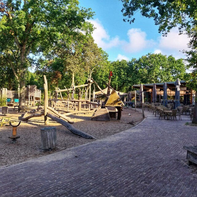 Review Camping Geversduin: met kinderen in de natuur vlakbij zee. De kinderen spelen in de grote houten speeltuin. Zelf zit je ondertussen lekker op het terras. Op dit terras kun je ook wat eten of drinken als je niet op de camping slaapt.