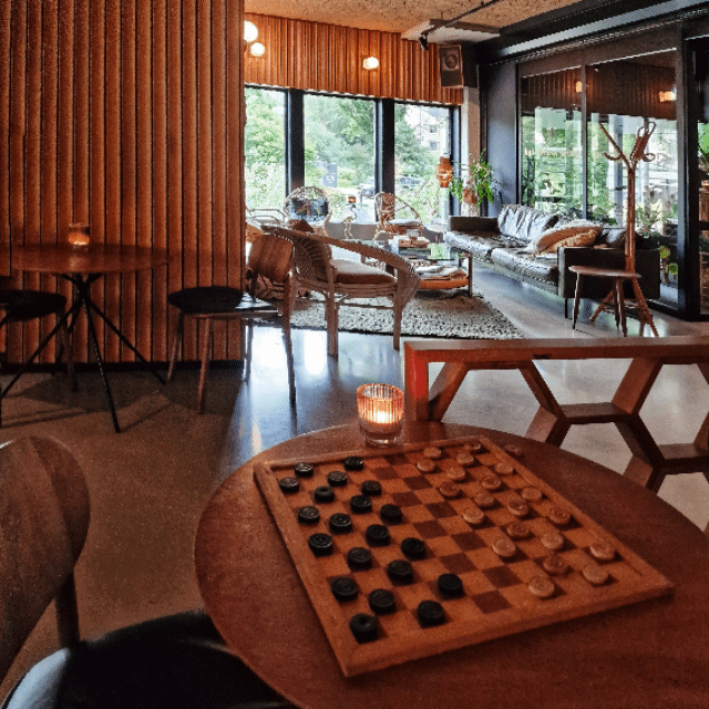 Wat een leuke plek: bij Hotel V op de Fizeaustraat. Komt het je bekend voor? Dat komt misschien door Teun en Gijs die er vroeger hun podcast opnamen. Wat een leuke plek, een heel fijn retro sfeertje. En het schaakbord en dambord gaan de kids ook tof vinden!
