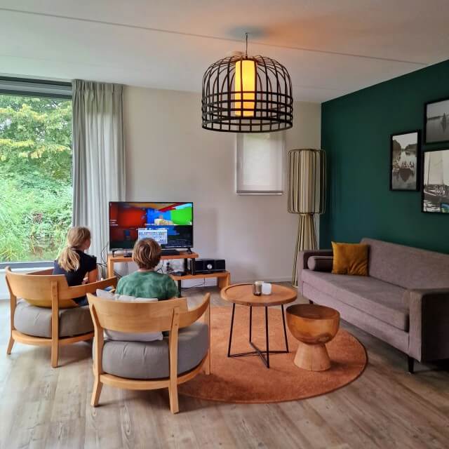 Review Landal Reeuwijkse Plassen met kinderen. De woonkamer van waterwoning 4L Vlist heeft een open keuken en grote ramen. Het is daarnaast sfeervol en modern ingericht.