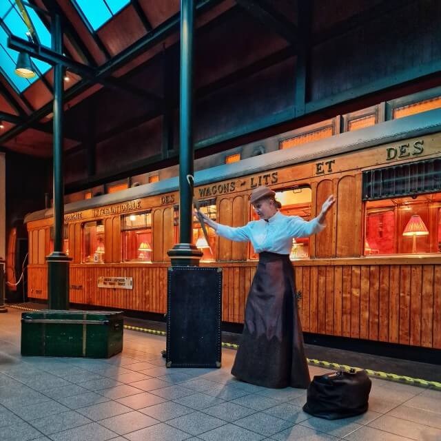 Je lijkt een theater in te stappen, maar opeens sta je op het perron naast de prachtige Orient Express. Toch is het ook een theater, want er zijn hier een paar keer per dag interactieve voorstellingen. Vraag bij binnenkomst even wanneer ze zijn. Wij werden door deze dame meegenomen naar Londen. 