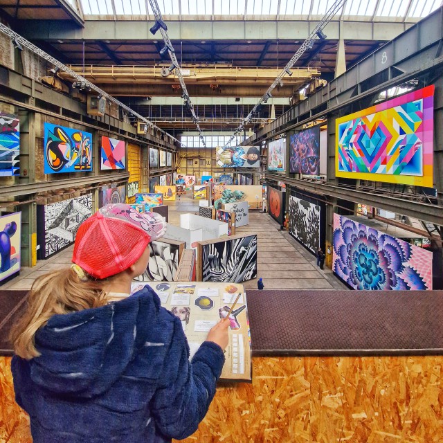 STRAAT museum Amsterdam met kinderen en tieners. Zoek je een hip kids uitje in Amsterdam Noord? STRAAT museum is leuk voor oudere kinderen en tieners. Je vindt er graffiti en street art in een stoere oude loods op de NDSM-werf. STRAAT museum heeft een speurtocht voor kinderen. Daarbij gingen we op zoek naar kunstwerken, beantwoordden we vragen en tekenden we een kunstwerk na. 