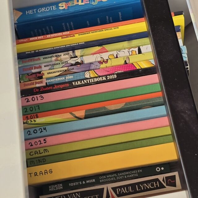 We hebben een bagagebak met vakken. Een van die bakken zit vol met tijdschriften. Op de oude Flow vakantieboeken zette ik het jaartal of thema. Voor de kids zit er een stapel Donald Duck vakantieboeken in.